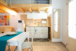 a small kitchen with a table and a refrigerator at Casa Polignano in Polignano a Mare