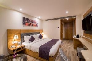 a hotel room with a bed and a television at Regenta Central Cassia Zirakpur Chandigarh in Chandīgarh