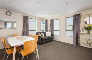 a living room with a table and chairs and a couch at City Center 2bdr apartment with views in Christchurch +7 photos