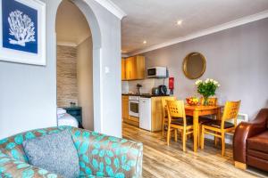 a living room and kitchen with a table and chairs at Newlands Holidays in Charmouth +69 photos