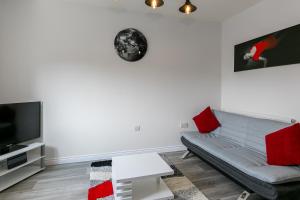 a living room with a couch and a tv at Coach House & Hot Tub Nr Bicester Village in Bicester