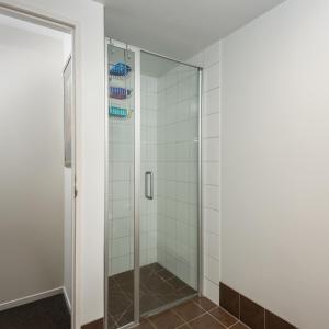 a shower with glass doors in a bathroom at City Center 2bdr apartment with views in Christchurch