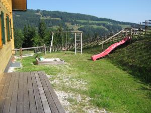 um parque infantil com um escorrega e um baloiço em Gerstbreinhütte em Bad Sankt Leonhard im Lavanttal