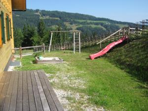 plac zabaw ze zjeżdżalnią i huśtawką w obiekcie Gerstbreinhütte w mieście Bad Sankt Leonhard im Lavanttal