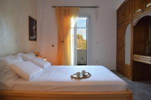a bedroom with a large white bed with a window at Villa de viento in Tripití