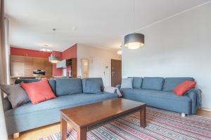 a living room with a blue couch and a coffee table at CITYSTAY Szafarnia Gdansk Apartment in Gdańsk