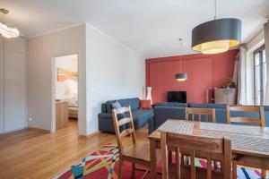 a living room with a blue couch and a table at CITYSTAY Szafarnia Gdansk Apartment in Gdańsk