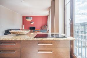 a kitchen with a counter top and a living room at CITYSTAY Szafarnia Gdansk Apartment in Gdańsk