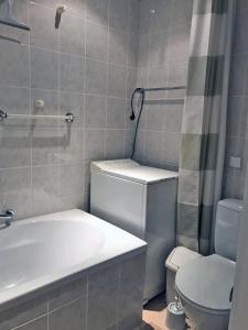 ein Badezimmer mit einer Badewanne, einem WC und einem Waschbecken in der Unterkunft Beach Paradise Apartments in Liepāja