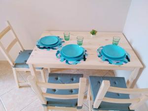 a table with blue plates and glasses on it at Atelier bed&bed in Messina