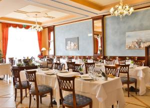 a restaurant with white tables and chairs and a chandelier at Best Western Classic Hotel in Reggio Emilia