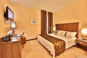 pokój hotelowy z łóżkiem i telewizorem z płaskim ekranem w obiekcie Best Western Hotel Libertà w mieście Modena +27 zdjęć