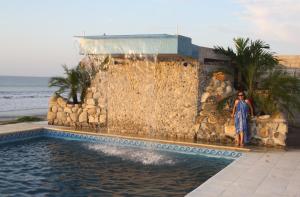 una mujer parada frente a una fuente de agua en Casa Blanca Hotel Boutique, en Santa Marianita