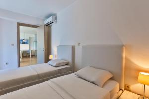 pokój hotelowy z dwoma łóżkami i lustrem w obiekcie Gufo Apart w Budvie