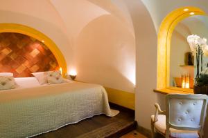 ein Schlafzimmer mit einem Bett und einem Stuhl in der Unterkunft Hôtel Le Belvédère in Porto-Vecchio
