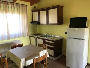 a kitchen with a table and a white refrigerator at Il Podere del Carlone in Vasto