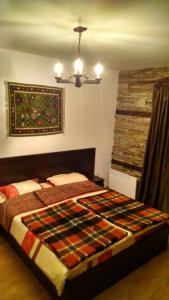 a bedroom with a bed with a quilt on it at Family Apartment "Cosy Nature" in Smolyan