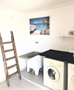 lavadero con escalera y lavadora en Appartamenti Le Mimose, en Santa Maria Navarrese