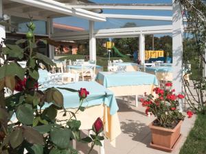 a patio area with tables, chairs and umbrellas at Hotel Cala Reale in Stintino