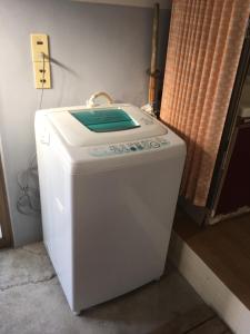 een speelgoedwasmachine in een hoek van een kamer bij Guest House Ilonggo in Tsu