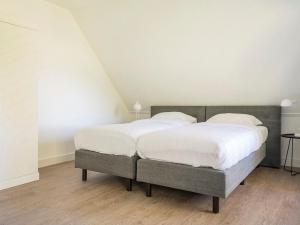 Dos camas en una habitación con sábanas blancas. en Apartment in De Cocksdorp near Beach, en De Cocksdorp