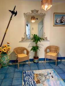 Habitación con 2 sillas y espejo. en Rooms B&B Albergo Riviera en Maiori