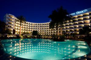 a hotel with a large swimming pool at night at Seaside Palm Beach in Maspalomas
