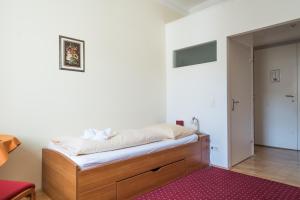 Schlafzimmer mit einem Bett und einem roten Teppich in der Unterkunft Gästehaus im Priesterseminar Salzburg in Salzburg