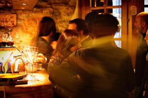 a group of people sitting at a bar at Aethos Saragano in Saragano