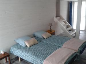 una camera da letto con letto con cuscini e scala di Gîte de Gravelle a Chavin