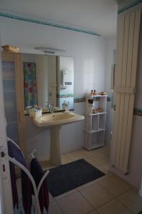 a bathroom with a sink and a kitchen with a refrigerator at gite Les Hauts de la gérardière in Vertou