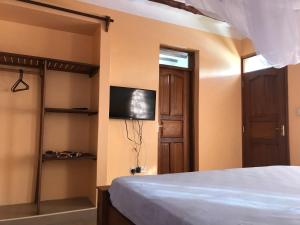 a bedroom with a bed and a flat screen tv at Lions Home in Diani Beach