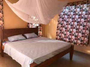 a bedroom with a bed with white sheets and a window at Lions Home in Diani Beach +58 photos