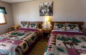 ein Schlafzimmer mit zwei Betten und Weihnachtsdecken in der Unterkunft Bear Tracks Inn in Lions Head