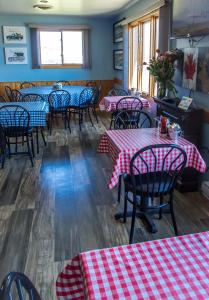 a restaurant with red and white checkered tables and chairs at Bear Tracks Inn in Lion's Head