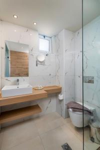 a bathroom with a sink and a toilet and a mirror at Sunny Days in Tigaki