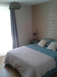 una camera da letto con un letto con una coperta bianca e una finestra di Gîte de Gravelle a Chavin