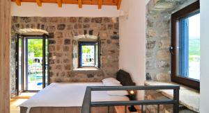 una camera con tavolo e parete in pietra di Trip to a Tivat