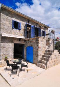 a stone house with a blue door and a patio at Trip to in Tivat