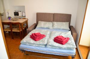Bett mit zwei roten Kissen auf einem Zimmer in der Unterkunft Appartamenti Frapporta in Tenno