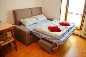 eine Couch mit zwei roten Kissen darüber in der Unterkunft Appartamenti Frapporta in Tenno