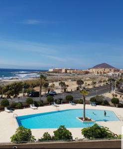 a swimming pool with a view of the ocean at Residencial Los Martines in El Médano