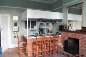 a kitchen with a bar with chairs and a fireplace at Heathcliff House B&B Exclusively for Adults Free large carpark in Torquay