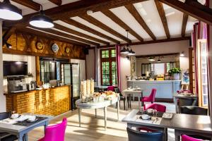 a restaurant with tables and chairs and a kitchen at Logis Hostellerie Du Grand Duc hôtel restaurant in Gincla