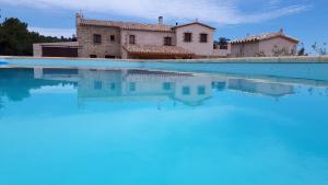 a villa with a swimming pool in front of a house at La Masia de Montpedrós in Peralada