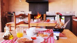 a table with a plate of food and a fireplace at La Masia de Montpedrós in Peralada