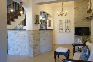 a living room with a stone wall and a tv at Apart Boutique Giorgos in Ammouliani