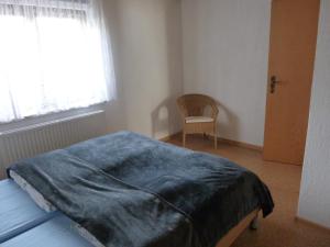 um quarto com uma cama com um cobertor azul em Jürgen+Carmen Essbüchl em Rodewisch