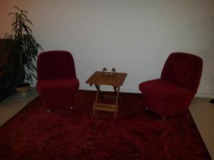 2 rote Stühle und ein Tisch in einem Zimmer in der Unterkunft Prof Loft Berlin in Berlin