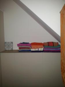 einen Haufen Handtücher, die auf einem Regal in einem Zimmer liegen in der Unterkunft Prof Loft Berlin in Berlin